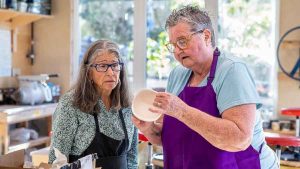 Randy Wilson, left, gets a lesson on preparing bowls for glazing from Cheryl Lashley. Ashland.news photo by Bob Palermini