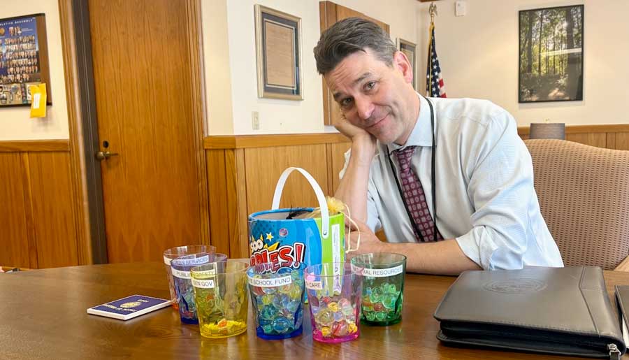 Senate President Rob Wagner, D-Lake Oswego, poses next to the marbles he uses to simulate the Oregon budget. Oregon lawmakers expect to have fewer marbles to allocate given changes to state finances since the end of the legislative session. Oregon Capital Chronicle photo by Julia Shumway