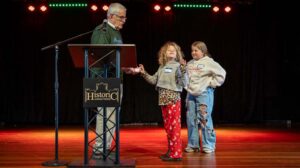 Asa and Zinnia help Jeff Golden kick off the Abundance Swap by drawing colors to set the order for participants to select gifts. Ashland.news photo by Bob Palermini